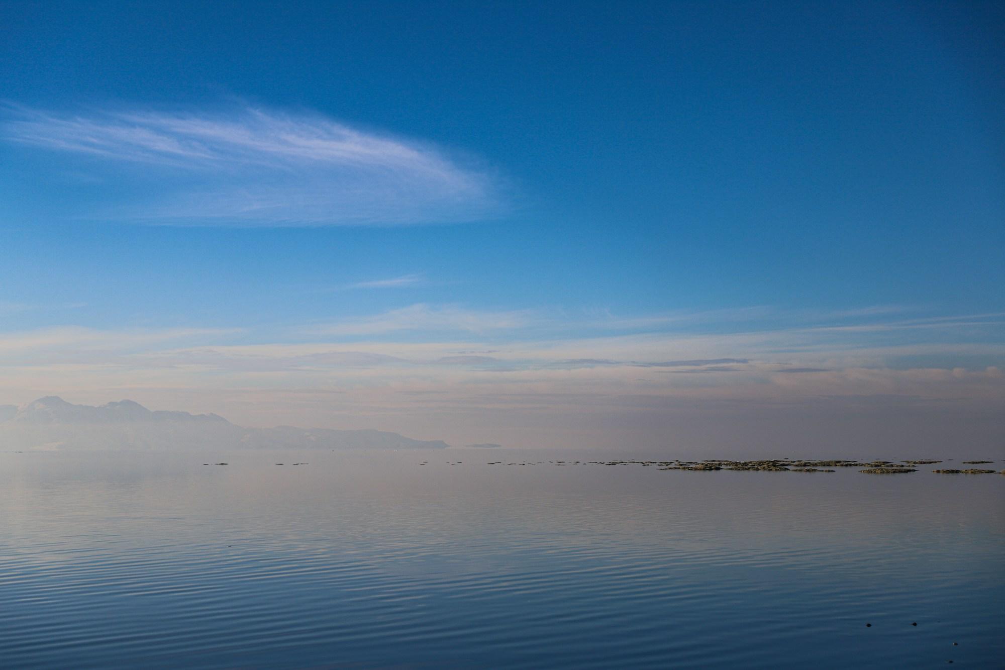 The blue water and distant horizon of the Great Salt Lake under a clear sky